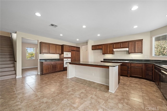 kitchen with white appliances, a kitchen bar, and a center island