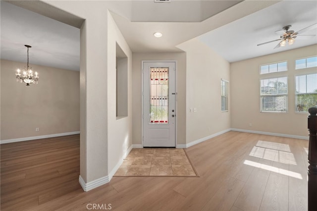 entrance foyer with ceiling fan with notable chandelier and light hardwood / wood-style floors