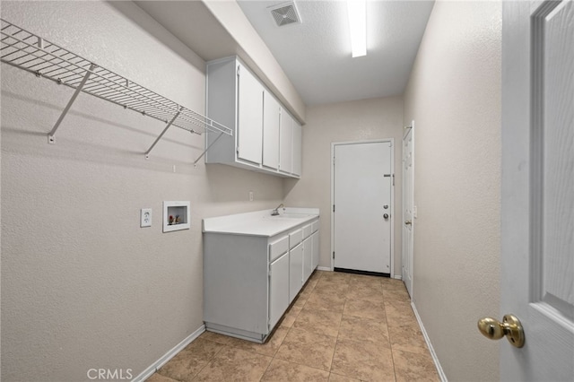 clothes washing area with cabinets and hookup for a washing machine