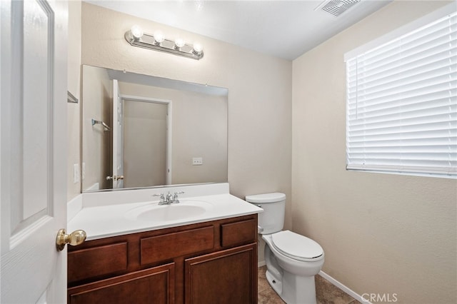 bathroom featuring vanity, tile patterned flooring, and toilet