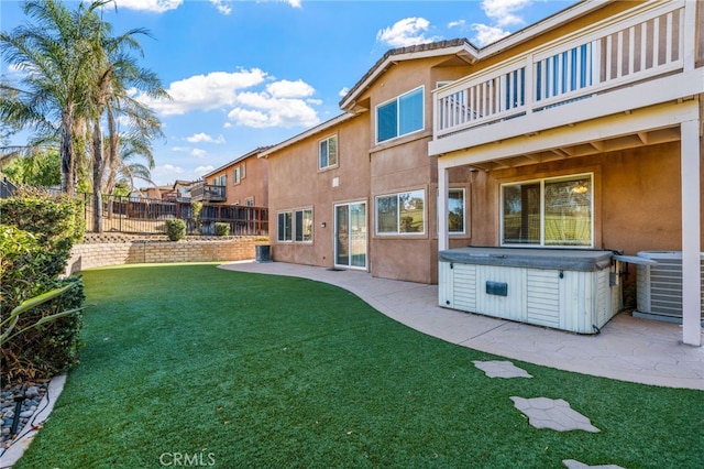 view of yard with a balcony, a hot tub, a patio area, and central air condition unit