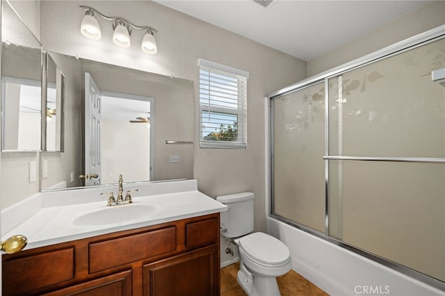 full bathroom featuring tile patterned floors, toilet, combined bath / shower with glass door, vanity, and ceiling fan