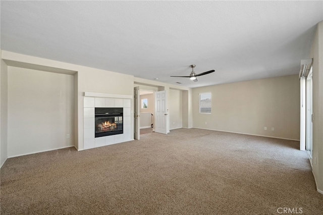 unfurnished living room with ceiling fan, carpet flooring, and a tile fireplace