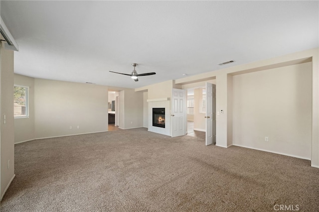 unfurnished living room with ceiling fan and carpet flooring