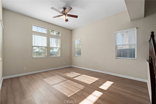 empty room featuring hardwood / wood-style flooring, a wealth of natural light, and ceiling fan