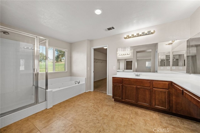 bathroom featuring tile patterned flooring, vanity, and separate shower and tub