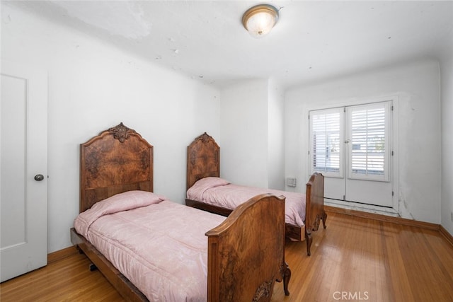 bedroom featuring baseboard heating and light hardwood / wood-style floors