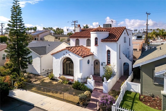 mediterranean / spanish-style house with central AC unit