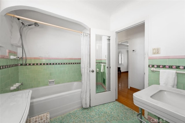 bathroom with tile walls and shower / bath combination with curtain