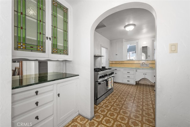 kitchen with double oven range and white cabinets