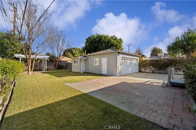 view of yard with a garage, a patio, and an outdoor structure