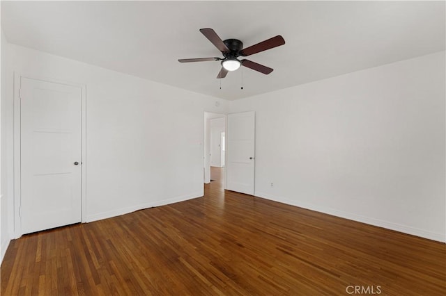 empty room with ceiling fan and dark hardwood / wood-style floors