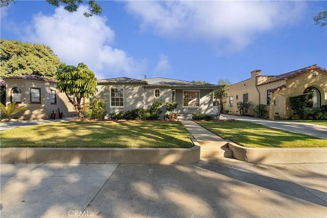 mediterranean / spanish-style house featuring a front yard