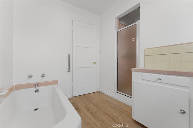 bathroom featuring wood-type flooring and plus walk in shower