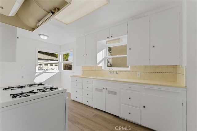 kitchen featuring backsplash, sink, white cabinetry, light hardwood / wood-style flooring, and white range with gas stovetop