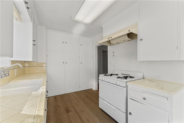 kitchen featuring exhaust hood, hardwood / wood-style floors, sink, white cabinetry, and white gas stove