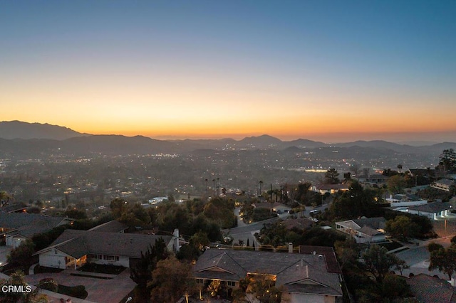 aerial view at dusk featuring a mountain view