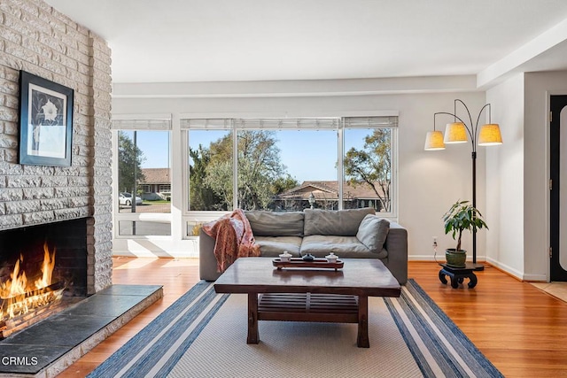 living room featuring a healthy amount of sunlight, a fireplace, and hardwood / wood-style floors