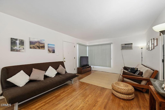 living room featuring light hardwood / wood-style flooring and an AC wall unit