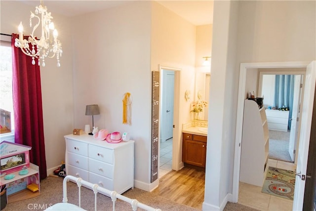 bedroom with light hardwood / wood-style flooring and a chandelier