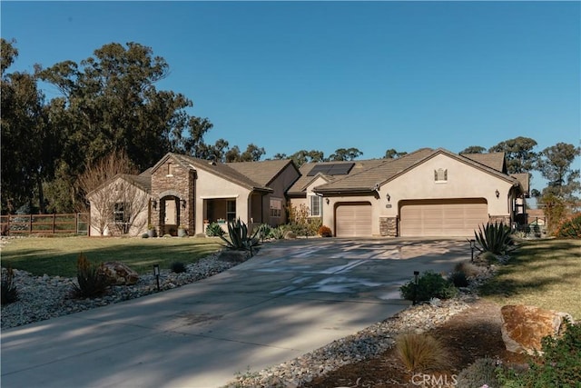 view of front of house featuring a garage, a front yard, and solar panels