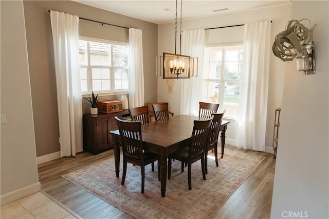 dining space with a chandelier and light wood-type flooring