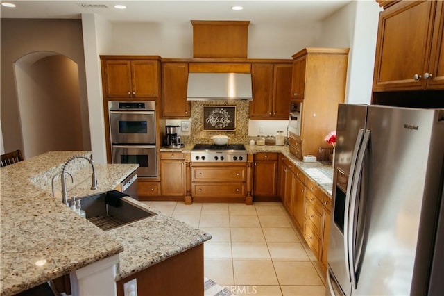 kitchen with sink, ventilation hood, a breakfast bar area, and appliances with stainless steel finishes