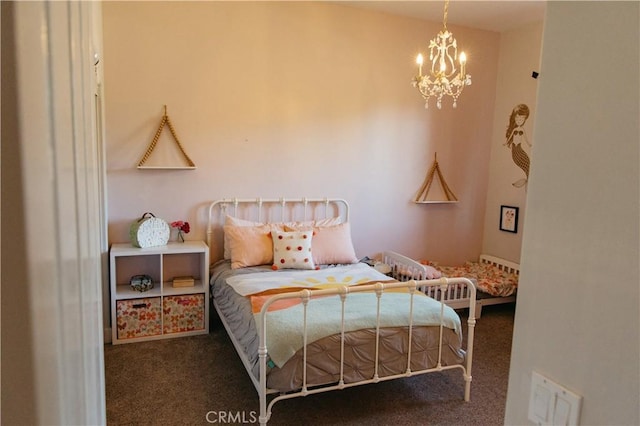 bedroom with dark carpet and a chandelier