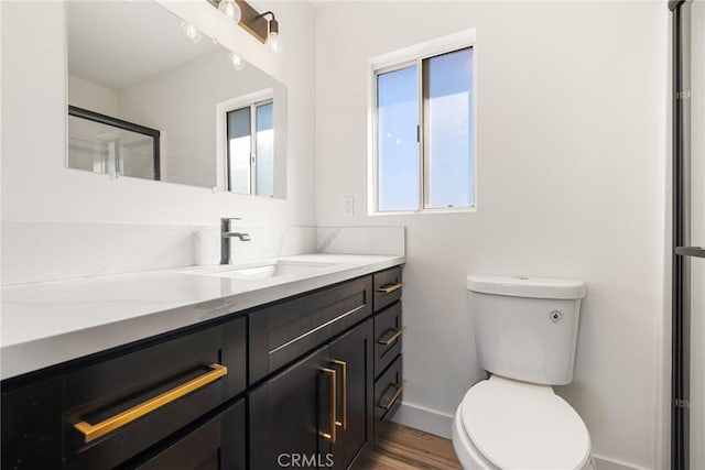 bathroom featuring hardwood / wood-style flooring, vanity, an enclosed shower, and toilet