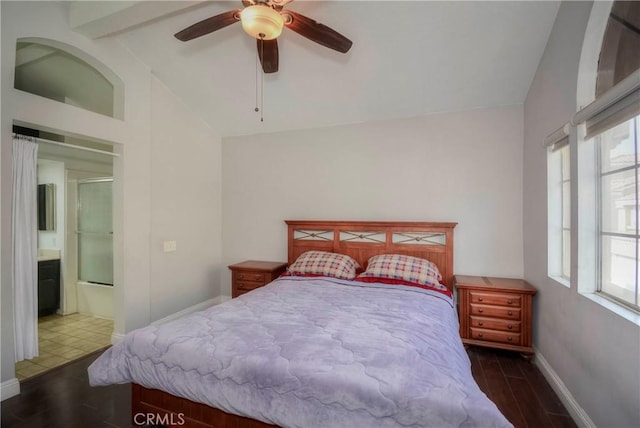 bedroom with ceiling fan, connected bathroom, dark hardwood / wood-style floors, and lofted ceiling with beams