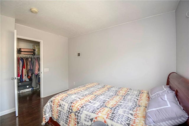 bedroom with a closet and dark wood-type flooring