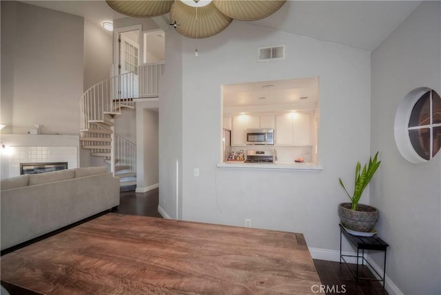 interior space featuring ceiling fan, dark wood-type flooring, and lofted ceiling