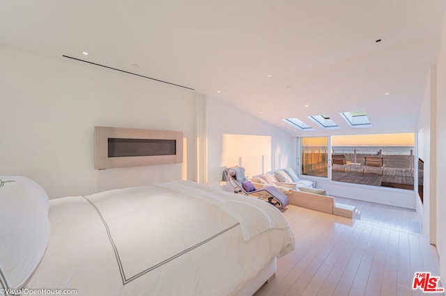 bedroom with hardwood / wood-style floors and lofted ceiling