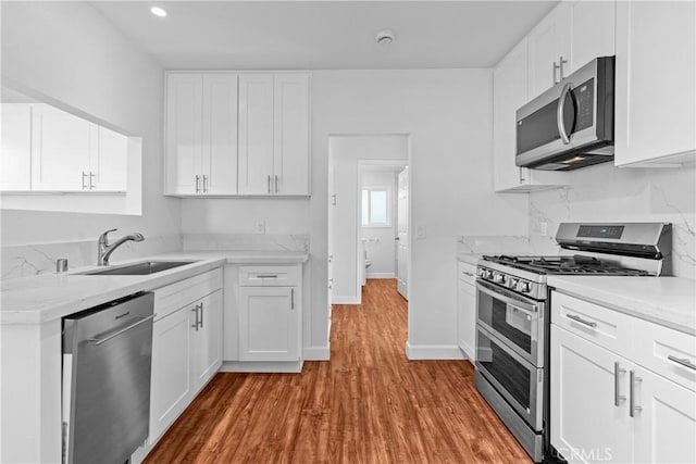 kitchen with white cabinetry, appliances with stainless steel finishes, and sink