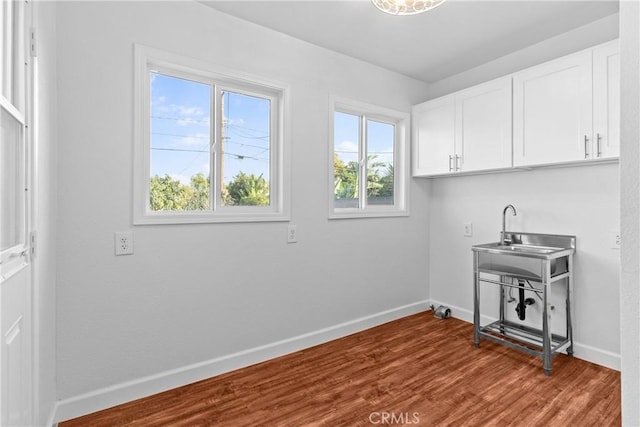 laundry room featuring hardwood / wood-style floors, sink, and cabinets