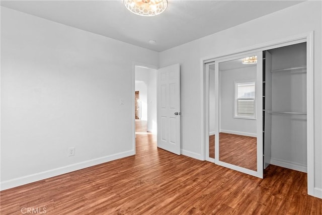 unfurnished bedroom with a closet and dark hardwood / wood-style floors