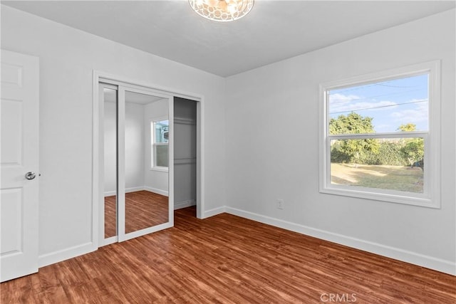 unfurnished bedroom featuring hardwood / wood-style floors and a closet