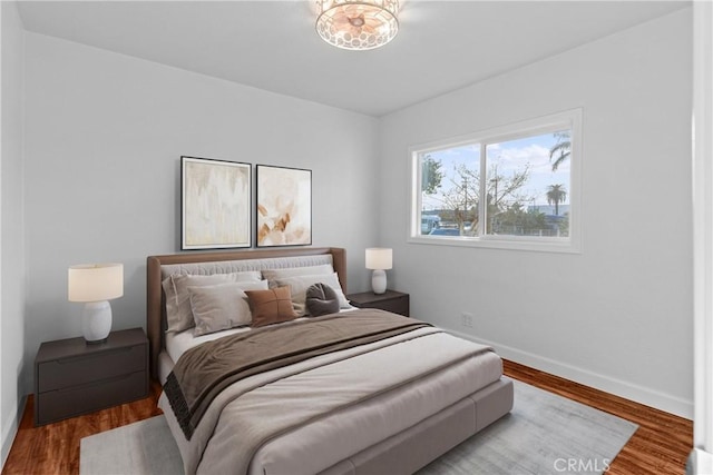 bedroom featuring hardwood / wood-style flooring and an inviting chandelier