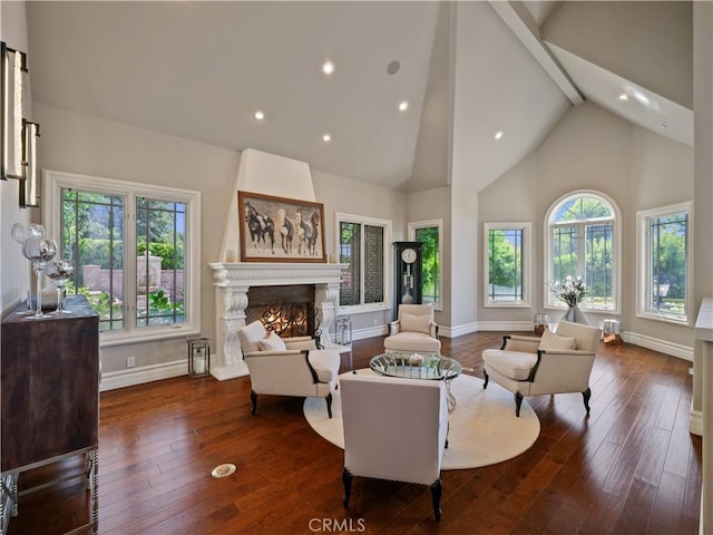 living room featuring dark wood-type flooring, beam ceiling, a wealth of natural light, and a high end fireplace