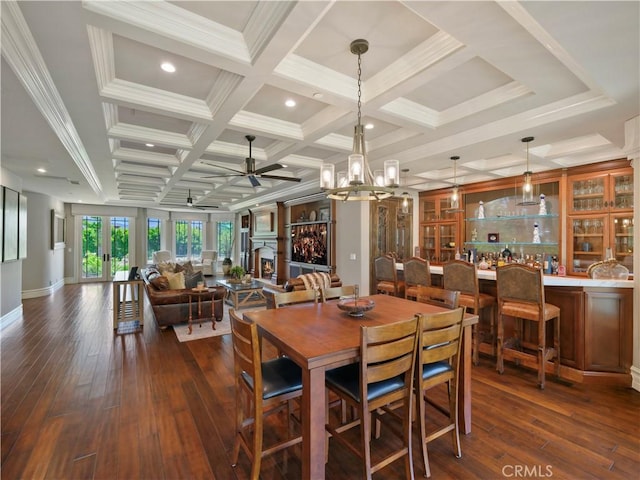 dining space featuring coffered ceiling, beamed ceiling, ceiling fan, and dark wood-type flooring