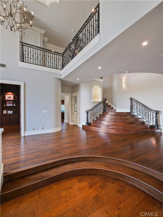 stairway with a towering ceiling and hardwood / wood-style floors