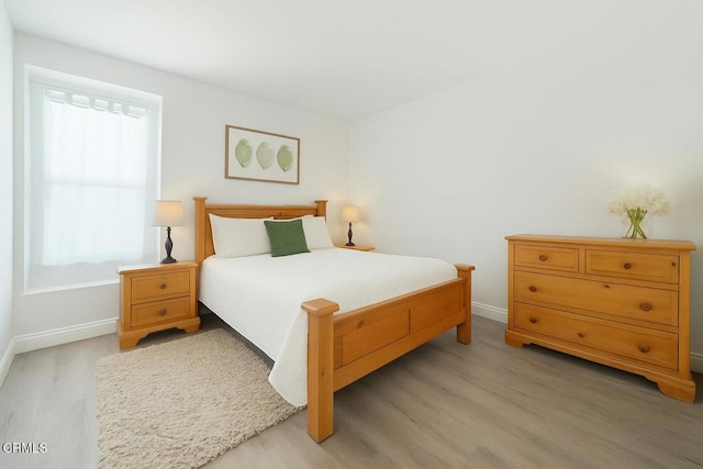 bedroom featuring baseboards and light wood-style floors
