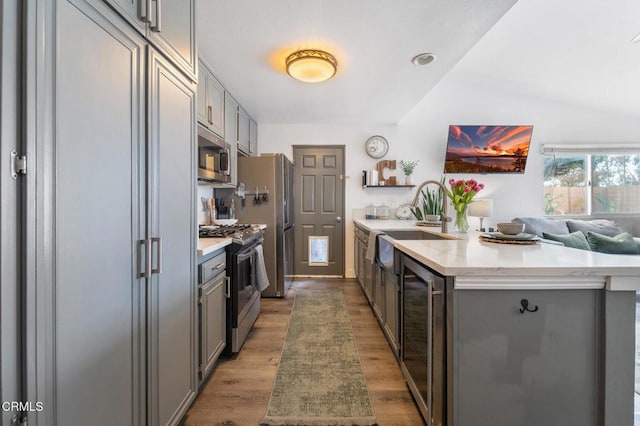 kitchen featuring a peninsula, wine cooler, gray cabinetry, and stainless steel appliances