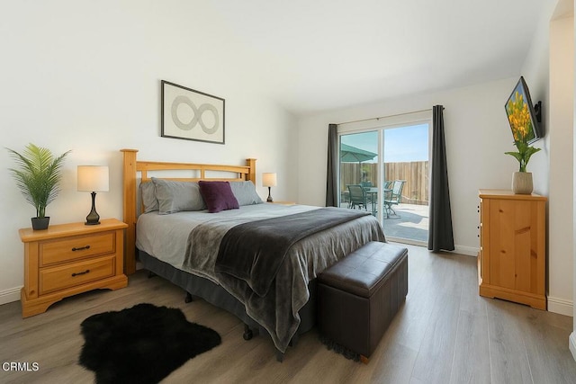 bedroom featuring light wood-style floors, baseboards, and access to exterior