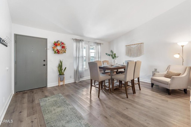 dining area with baseboards and wood finished floors