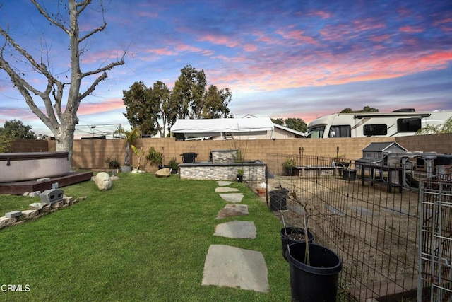 yard at dusk featuring a fenced backyard