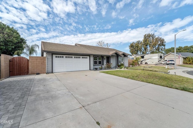 single story home with driveway, a tile roof, a front yard, a gate, and a garage