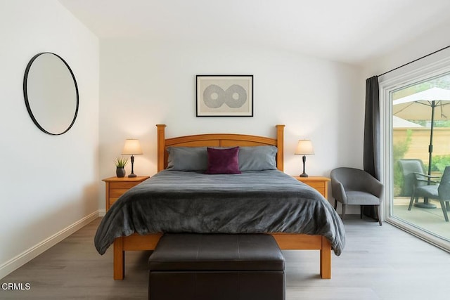 bedroom with baseboards, access to outside, and wood finished floors