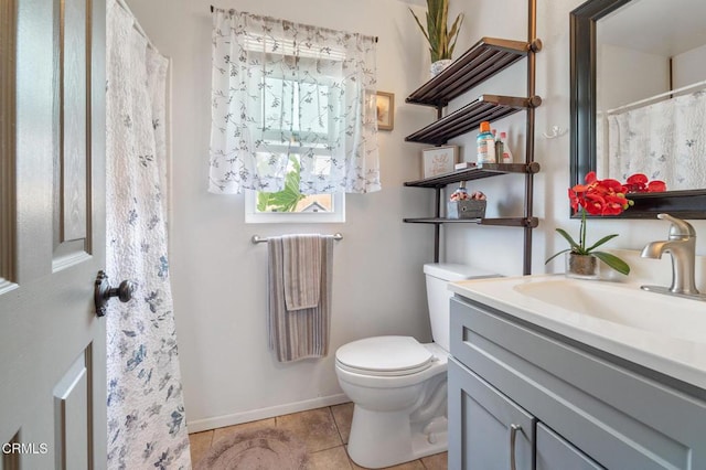 bathroom featuring toilet, baseboards, tile patterned flooring, and vanity