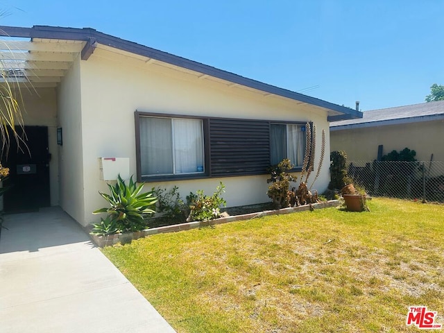 view of side of home with a yard and a carport